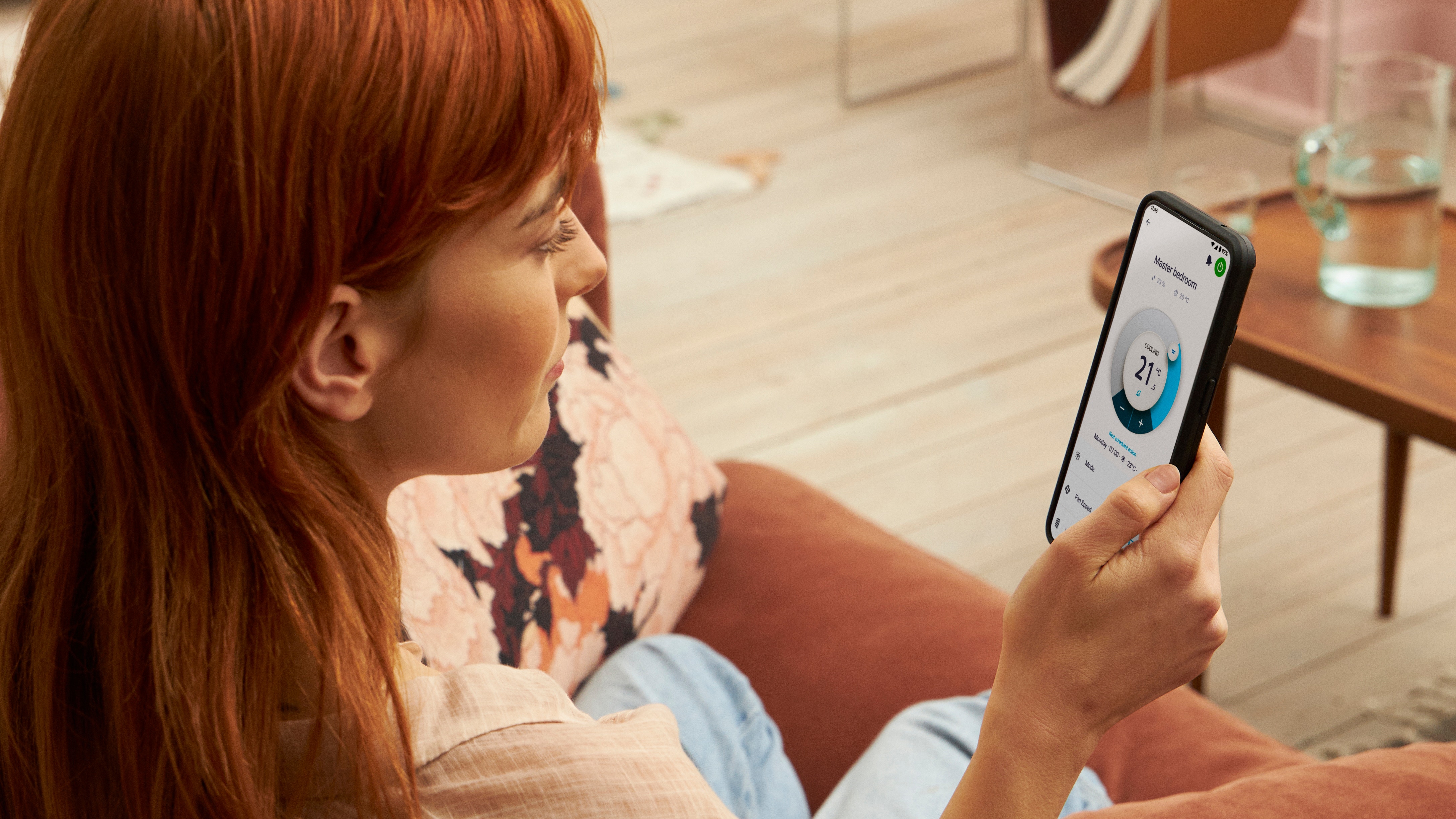 Vrouw die haar verwarmingsoplossing regelt met een app Vrouw die haar verwarmingsoplossing regelt met een app