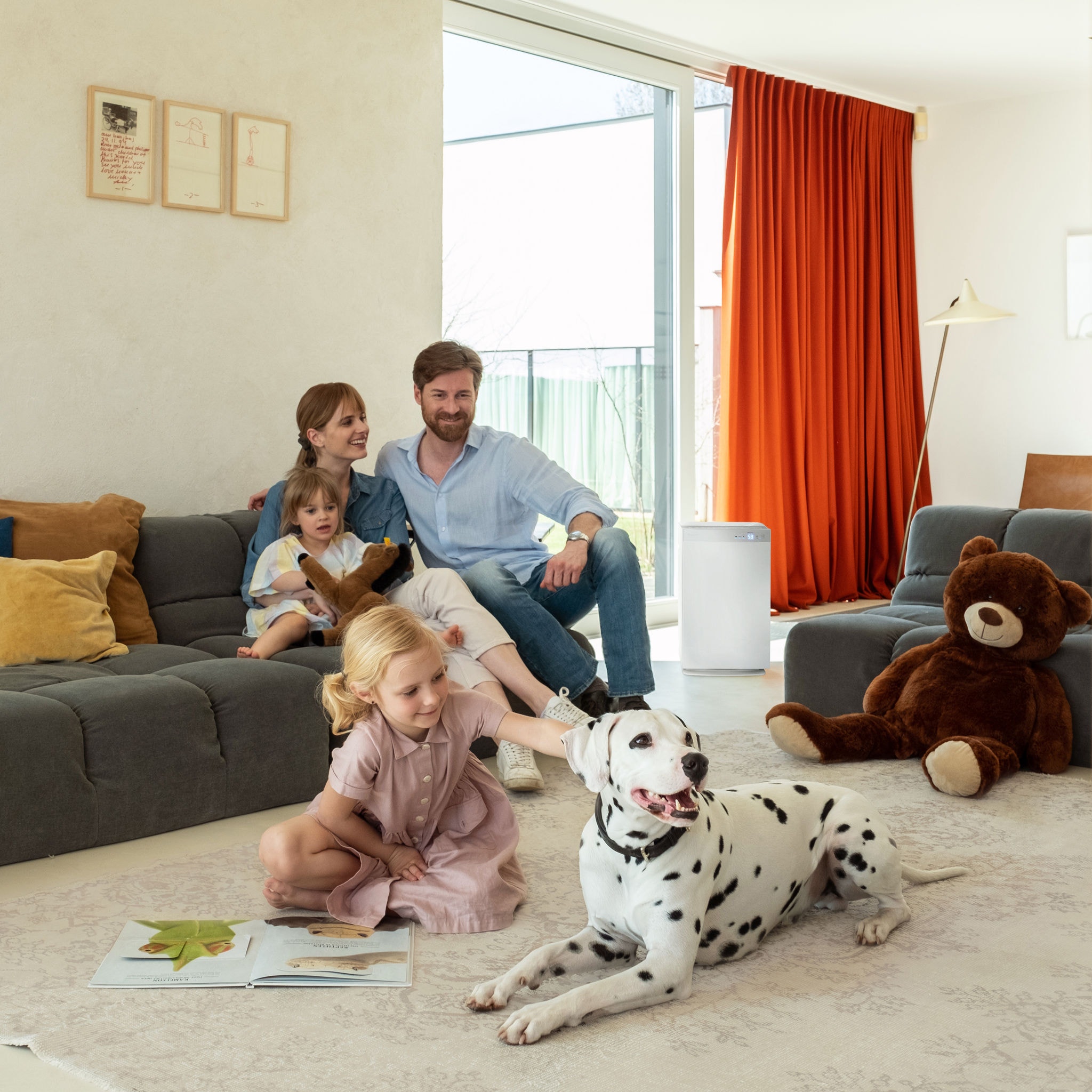 Gezin met twee kinderen en een Dalmatiër ontspannen in de woonkamer met een goede binnenluchtkwaliteit