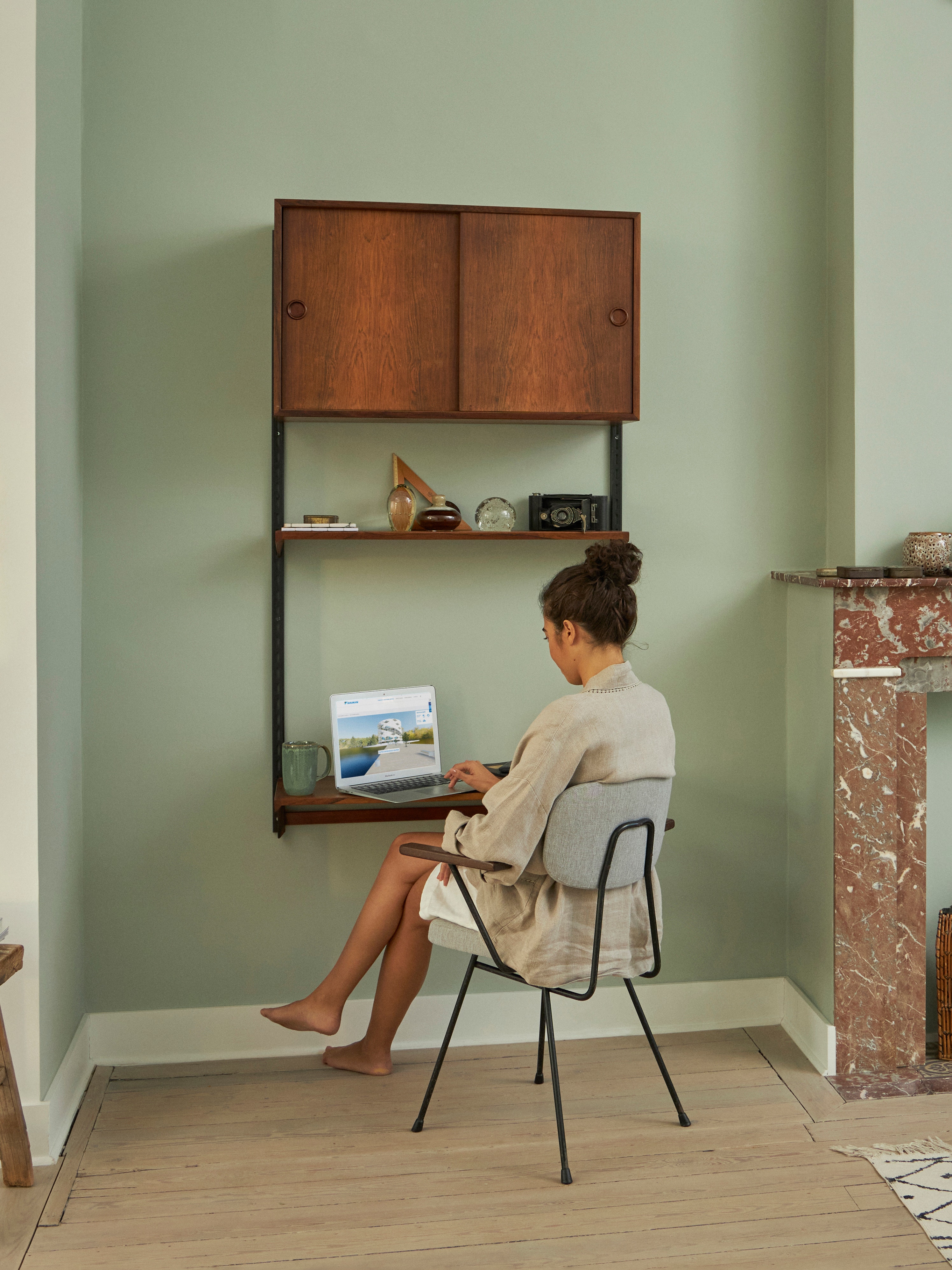 Vrouw die aan haar bureau zit en de Virtuele Showroom bezoekt op haar laptop