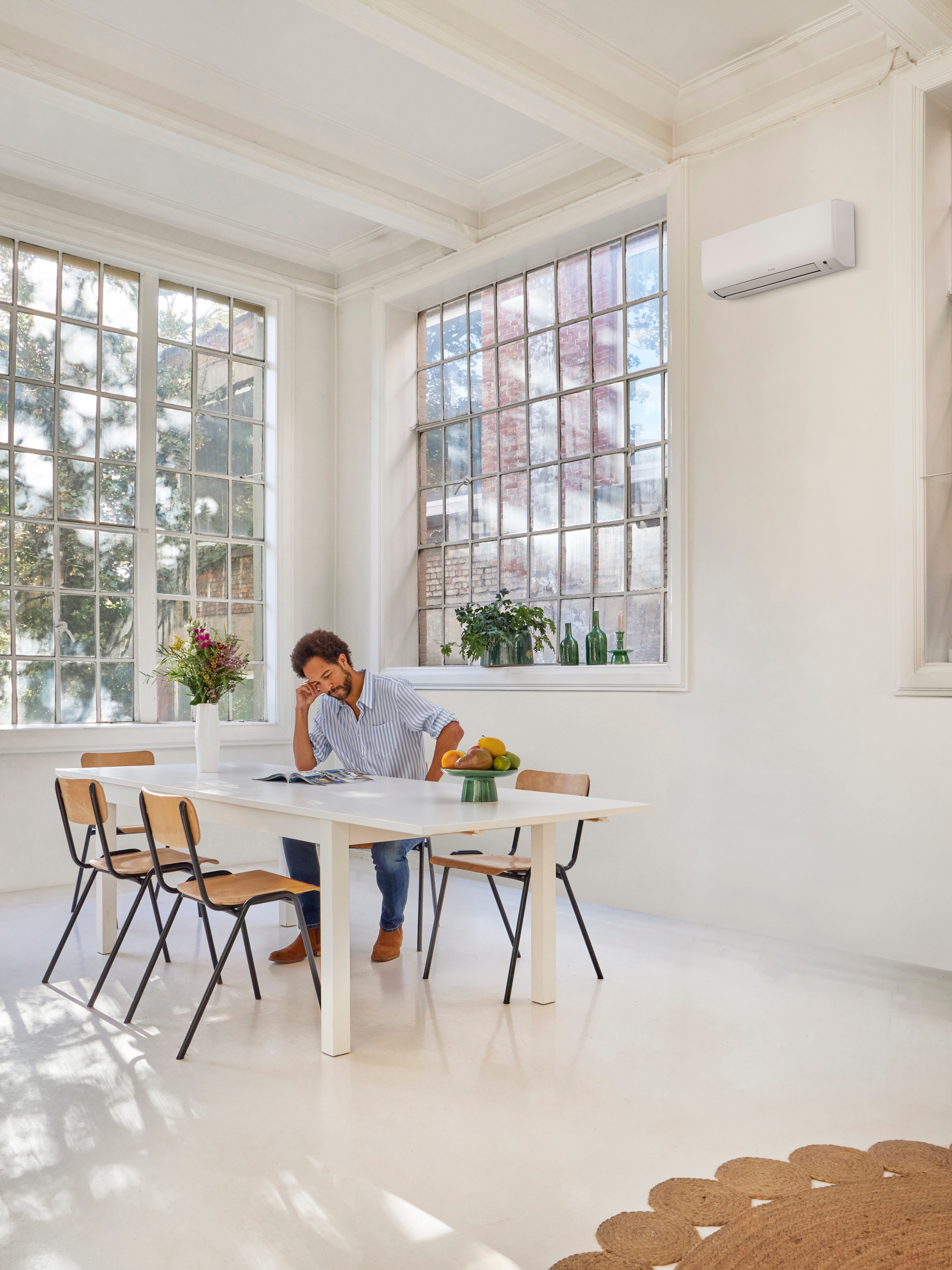 Man is reading at the table while enjoying the perfect temperature inside his home