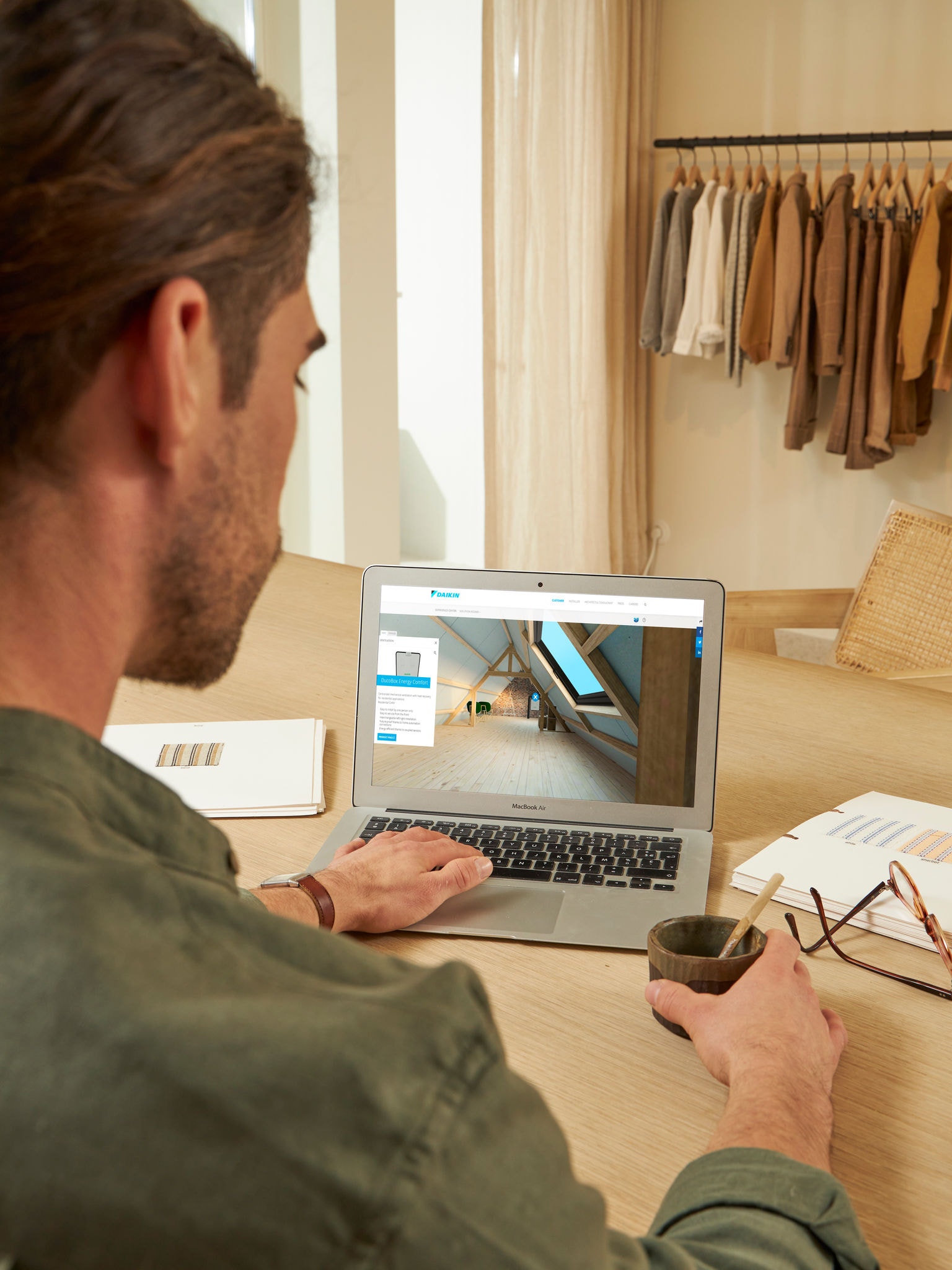 Man bekijkt ventilatieopties in de Virtuele Showroom via zijn laptop