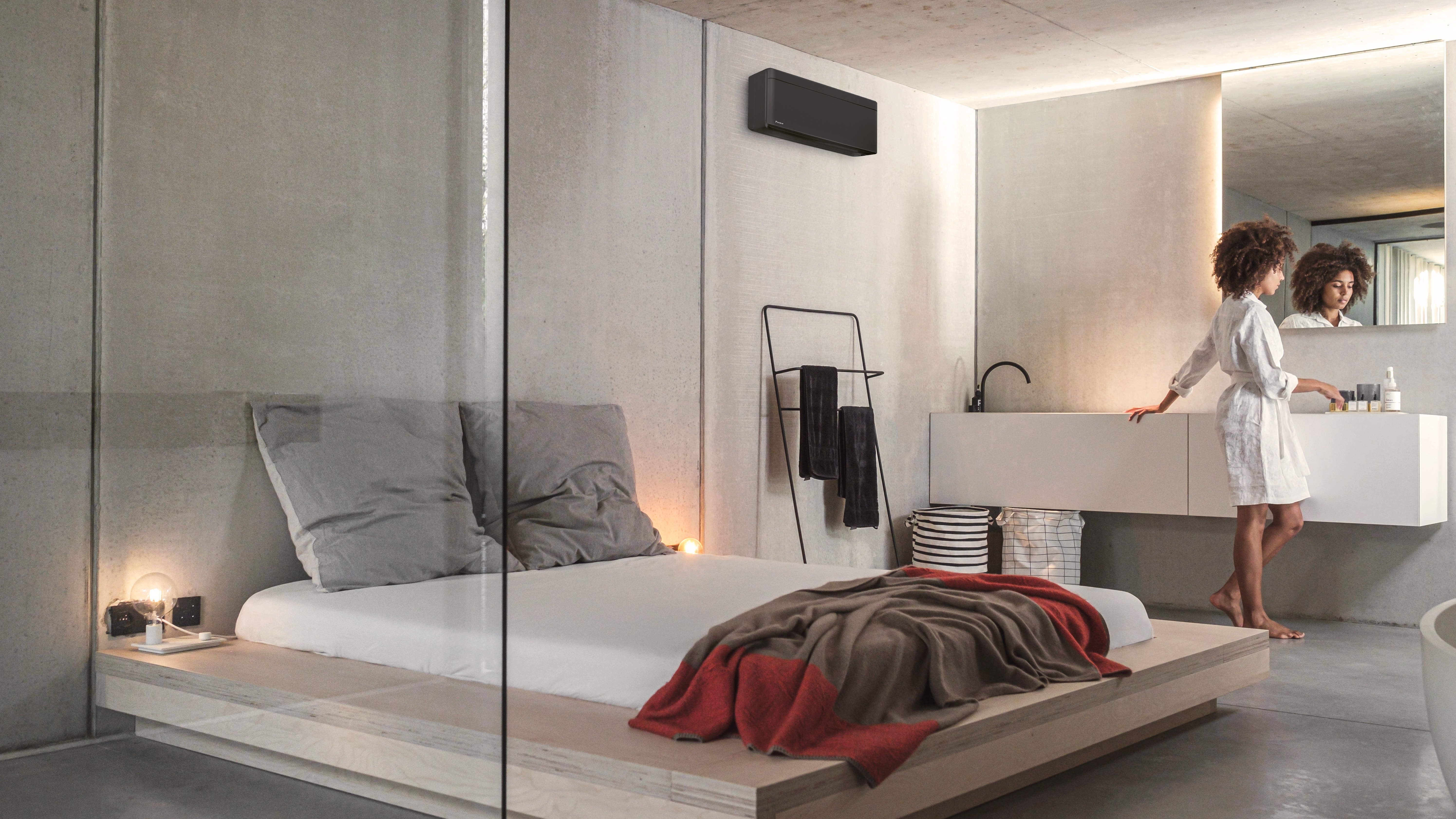 Een vrouw bereidt zich voor op de dag in haar slaapkamer met geïntegreerde badkamer die wordt verwarmd en waarin de lucht wordt geconditioneerd door een Stylish-binnendeel